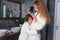 Mom and son have fun together in the bathroom. Beautiful mother with her little son dressed in bathrobe are relaxing and