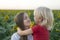 Mom and son looks each others . Portrait of happy mother and son. Sunflower field background