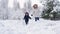 Mom and son are running in a snowy winter forest, happy parenthood and family vacation, slow motion