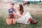 Mom and son together on a picnic in the field. Horse in the background