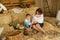 Mom with son in Ukrainian embroidered shirts, sit on hayloft, play with chickens on Easter holidays