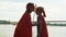 Mom in superhero costume kisses son forehead, embracing, support in beginnings