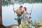 Mom swings with her daughter on a rope swing against the backdrop of a forest lake reflecting the sky. Family concept