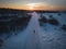 Mom takes her daughter on a sled in winter along the road at sunset in Paldiski, view from a drone