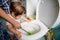 Mom teaches a child to clean. cleaning after the baby. clogged toilet. Mom and baby clean the toilet. House cleaning