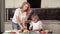 Mom teaches daughter to cook sandwiches for breakfast, bread with salmon and vegetables, cooking sandwich in the kitchen