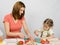 Mom teaches daughter to six-year cut with a knife products for cooking at the kitchen table