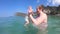 Mom teaches diving a baby in the sea. One year old baby for the first time at sea. Summer family vacation in a tropical climate an