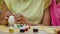 Mom teaches her daughter to paint eggs with paints and brush. African American woman and little girl with bunny ears are