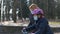 Mom teaches her daughter to ride a bike in the city Park. they are wearing protective helmets and medical masks. The concept of