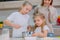 Mom teaches her daughters to cook dough in the kitchen