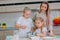 Mom teaches her daughters to cook dough in the kitchen