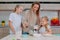 Mom teaches her daughters to cook dough in the kitchen