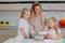 Mom teaches her daughters to cook dough in the kitchen