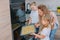 Mom teaches her daughters to cook in the kitchen. The family bakes cookies in the oven