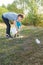 Mom teaches her son to clean up trash in nature. The topic of environmental pollution by garbage