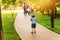 Mom teaches her son to ride a toy car in the park. Preschooler driving his toy car outdoors in summer