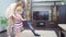 mom teaches little daughter to clean carpet in room with vacuum cleaner