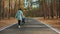 Mom teaches little son to ride a balance bike on the road