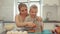 Mom teaches son to rub carrot. They are laughing. A young beautiful mother with in white shirt and cute son cook in a