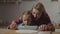 Mom teaching child rolling pastry with rolling pin