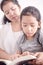 Mom teaching daughter to reading a book