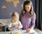 Mom teaching small child to cook while spending time at home