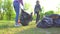 Mom and teen daughter collect garbage in plastic bags in park concept