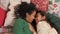 Mom tickles and kisses girl on nose in Christmas atmosphere