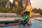 Mom with a toddler who is sitting in a stroller walks on a pontoon pier against the background of boats. Very early morning, the