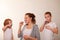 Mom and two blond boys brush their teeth