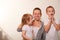 Mom and two blond boys brush their teeth