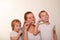 Mom and two blond boys brush their teeth