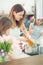 Mom with two young twins daughters in the kitchen cooking spaghetti