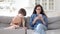 Mom use smartphone gadget sit together with small son playing game on digital tablet on sofa at home