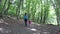 Mom walks her daughters hand with a pink backpack in the woods. Healthy lifestyle. Family walk in the woods outdoors