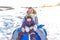 Mom woman with child boy 3 years old, sitting on inflatable tubing, rolling down slide resting winter in fresh air