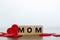 MOM word written on wooden cubes with red hearts around. Mother`s day concept