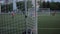 The moment of the goal at the training of the football team. Shooting from behind the gate through the net. Close-up