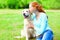 Moment of happiness! Happy owner woman is hugging kiss Golden Retriever dog on grass