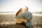 Moment of intimacy to be treasured. Rearview shot of a loving young couple sitting on the beach in an intimate way.