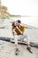 A moment before a kiss. Young couple is having fun and hugging on the beach. Beautiful girl embrace her boyfriend from