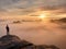 Moment of loneliness on exposed rocky summit. Man in black enjoy marvelous view. Hiker sit on the peak