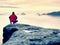 Moment of loneliness on exposed rocky summit. Man in black enjoy marvelous view. Hiker sit on the peak