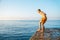 Moment of schoolboy jumping from pier into sea doing tricks