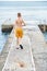 Moment of schoolboy walks on pier watching seascape