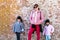 Mommy and her identical twins happy pose with old brick wall background