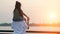 Mommy holds daughter on shoulders looking at calm river