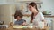 Mommy with kid cooks lady and boy cover table with flour