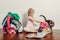 Mommy little helper. Cute Caucasian girl sorting clothes. Adorable funny child arranging organazing clothings. Kid with messy